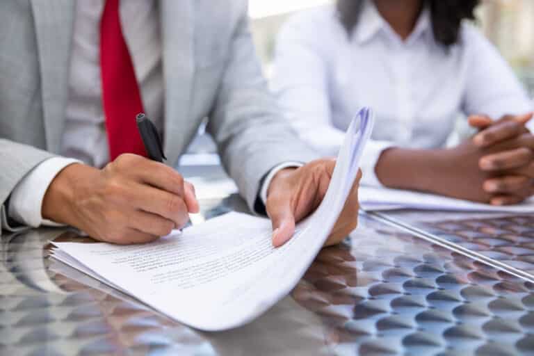 Toronto first-time home buyer signing legal documents with lawyer | Real estate legal paperwork and keys on desk Toronto home purchase | GTA home buyer reviewing closing documents with legal advisor